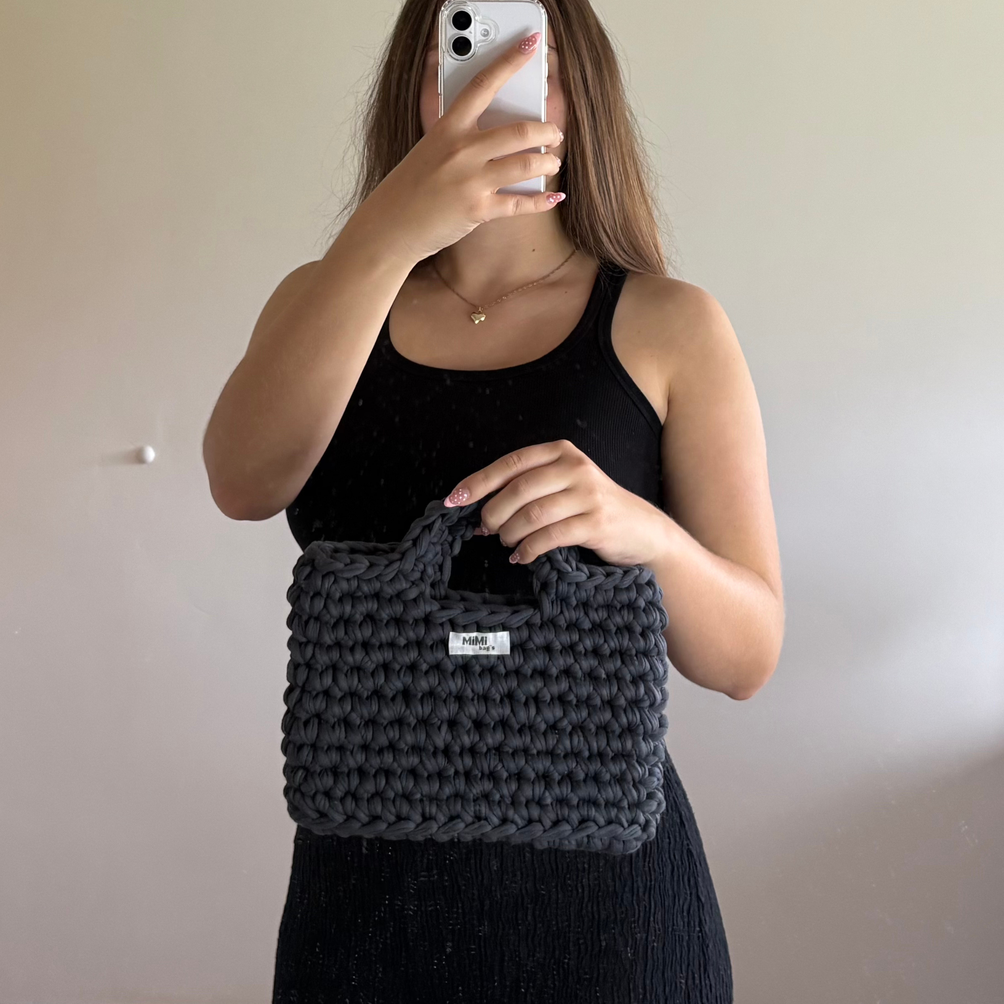 Črna torbica Handy v rokah modela – ročno kvačkana torba Dark Lush