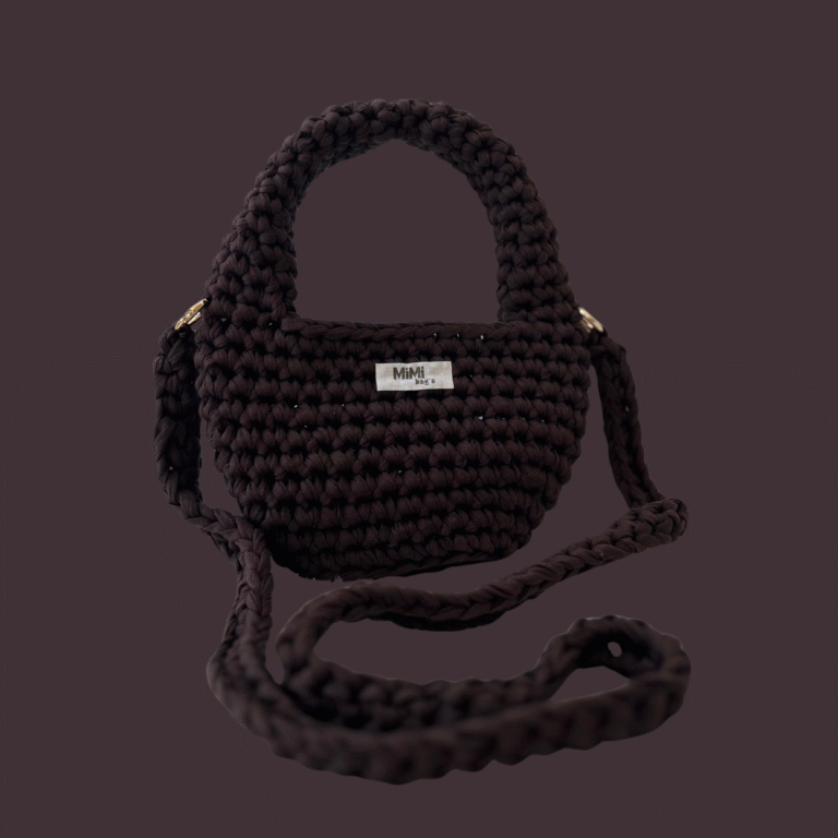 Rjava torbica Elegant Arc mini iz kolekcije mimibags, postavljena na enobarvnem ozadju